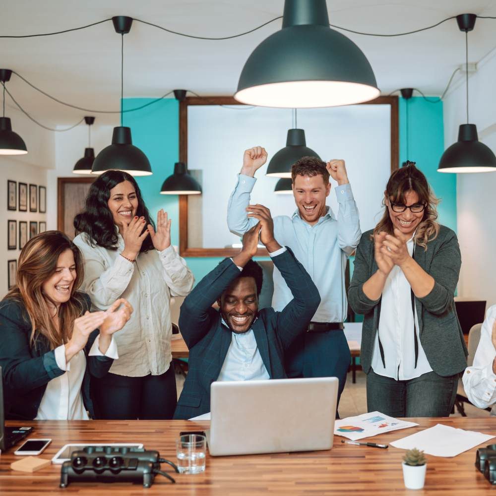 multiracial-coworkers-celebrating-victory-at-table-2023-11-27-04-51-01-utc (1)